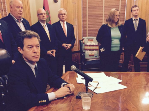 Photo by Jim McLean Gov. Sam Brownback answers reporter questions Thursday after signing a bill asserting state authority over new U.S. Environmental Protection Agency power plant rules. -