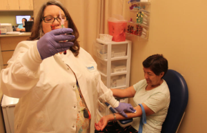 Technician Laneia Freel draws blood from patient Mariana Maldonado at one of the safety net clinics in Shawnee County.