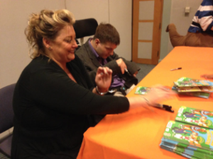 Author Michelle Bain and Ian Kuenzi, a Topekan with cerebral palsy, sign copies of Bain's new children's book that focuses on interacting with people who have disabilities. CREDIT ANDY MARSO/KHI NEWS