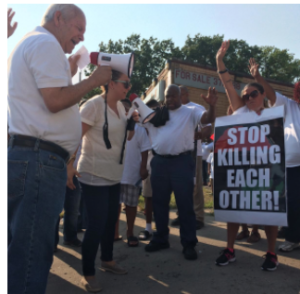 Pastor Francisco Lara (left) delivers a impassioned speech at an anti-violence rally in Kansas City, Kansas while his daughter, Raquel, translates his Spanish to English. CREDIT ALEX SMITH / HEARTLAND HEALTH MONITOR