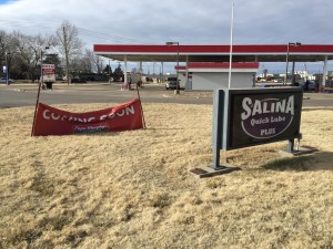 A banner announcing Papa Murphy's move sits next to a Salina Quick Lube sign near the building where the pizza chain will soon relocate to (Photo by Terry Tebrugge/Salina Post)