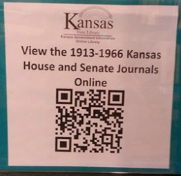 The State Library of Kansas is putting up small posters in the stacks with a QR-code link to online collections next to the matching paper document serials .