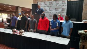 Head Coach Eric Clayton looks on as six new Liberty players sign their contracts Wednesday (Photo by Devin Hanney/Salina Post)