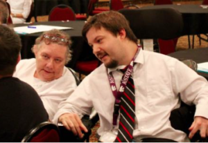 Photo by Andy Marso/KHI News Service Ian Kuenzi, right, a Topeka disability advocate who has cerebral palsy, questioned whether facilities for people with disabilities could truly be community-based. He and others attended a meeting Wednesday in Topeka where state officials gathered input on an upcoming federal rule regarding home and community-based services.