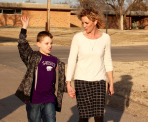 Photo by Andy Marso/KHI News Service File Parsons State Hospital and Training Center serves Kansans with intellectual disabilities like JJ Krentz, left, shown here earlier this year walking with his mother Tiffanie on the Parsons campus. The Kansas Department for Aging and Disability Services is moving about 20 people with intellectual and developmental disabilities out of a facility in Parsons and into community-based services because they don’t need the intensive support that the hospital provides.