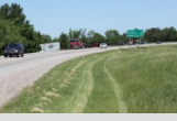 Photo by Andy Marso/KHI News Service First responders and tow trucks were on the scene in May when a semi went into a ditch and hit a tree along U.S. Highway 69. The driver appeared shaken but unhurt