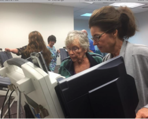 Photo by Jim McLean/KHI News Service Carolyn Megree of Spring Hill and Rene Pfaltzgraff of Paola try out an electronic voting machine at a training for poll workers in Miami County