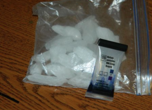 A bag containing what appears to be ice cubes. This is actually how methamphetamine became to be called “ICE”. The pouch lying on the bag containing the methamphetamine is called a field test kit. These kits allow officers to test the substance prior to sending it into a laboratory such as the Kansas Bureau of Investigation.-photo Pawnee County Sheriff