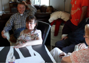 Photo by Andy Marso/KHI News Service Cornerstone Supports clients Tom Newman, left, and Kim Vermillion, seated at table, talk with Kim’s mom, Vickie, who owns Cornerstone. Vickie Vermillion said she's closing the company that provides support services to Kansans with intellectual and developmental disabilities because of a Medicaid reimbursement change the state made to help close a budget gap.
