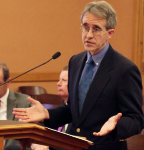 Photo by Andy Marso/KHI News Service Russ Sutter, an actuary with the firm Willis Towers Watson, told an oversight committee Wednesday that the Health Care Stabilization Fund’s board of governors had approved a surcharge reduction for participants. He said claims and related legal fees came in below expectations during the last fiscal year 