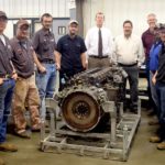 Diesel students (from left) Andy Henry, Steve Steger, Chad Beetch and Ben Wild, along with Mark Dyal, District Service Manager for Kenworth, John Logan, Service Manager for the MHC Kenworth dealership in Salina, and Diesel instructors Mike Parker, Gabe Winger and Mac Loucks stand around a PACCAR MX-13 Diesel engine donated to the college by Kenworth and MHC.