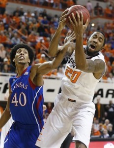 Oklahoma State forward Michael Cobbins (20) grabs a rebound in front of Kansas forward Kevin Young (40) during the first half of an NCAA college basketball game in Stillwater, Okla., Wednesday, Feb. 20, 2013. (AP Photo/Sue Ogrocki)