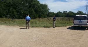 Law enforcement authorities search the tree line for a suspect on Monday afternoon in Saline County
