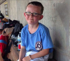 9-year old Liberal bat boy Kaiser Carlile in the Bee Jays dugout at Larks Park in mid July. (Courtesy Liberal Bee Jays)