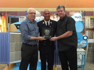 Retired FDNY Battalion Chief Jack Oehm (center) presents Sunflower Carpet One Store Managers Bernie Burghart (left) and David Rutz with a piece of steel from the World Trade Center (Photo by Terry Tebrugge/Salina Post)