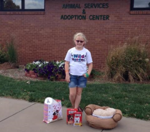 9-year-old Emily Streeter stands in front of the Animal Shelter with the items she collected to donate (Photos courtesy of Kelly Streeter)