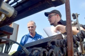 Mike Warren, left, Equipment Manager for Apac-Kansas, Inc. in Salina, and Salina Tech Diesel instructor Mac Loucks look over the hydraulic and electrical systems on the paver.