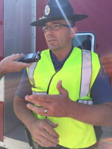 Trooper Ben Gardner speaks with the media near the scene of Thursday morning's accident.